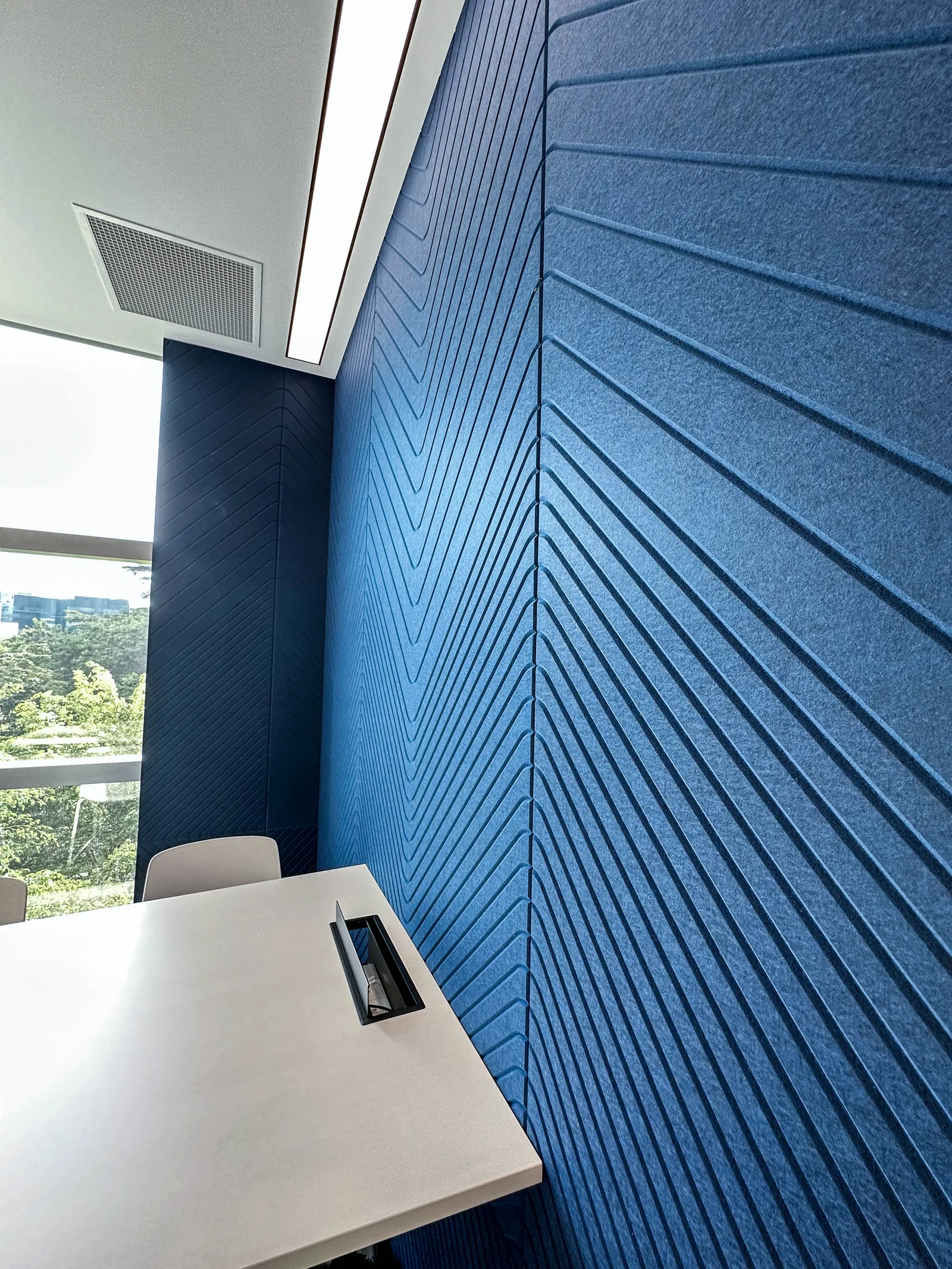Blue linear PET acoustic wall panels installed in a meeting room