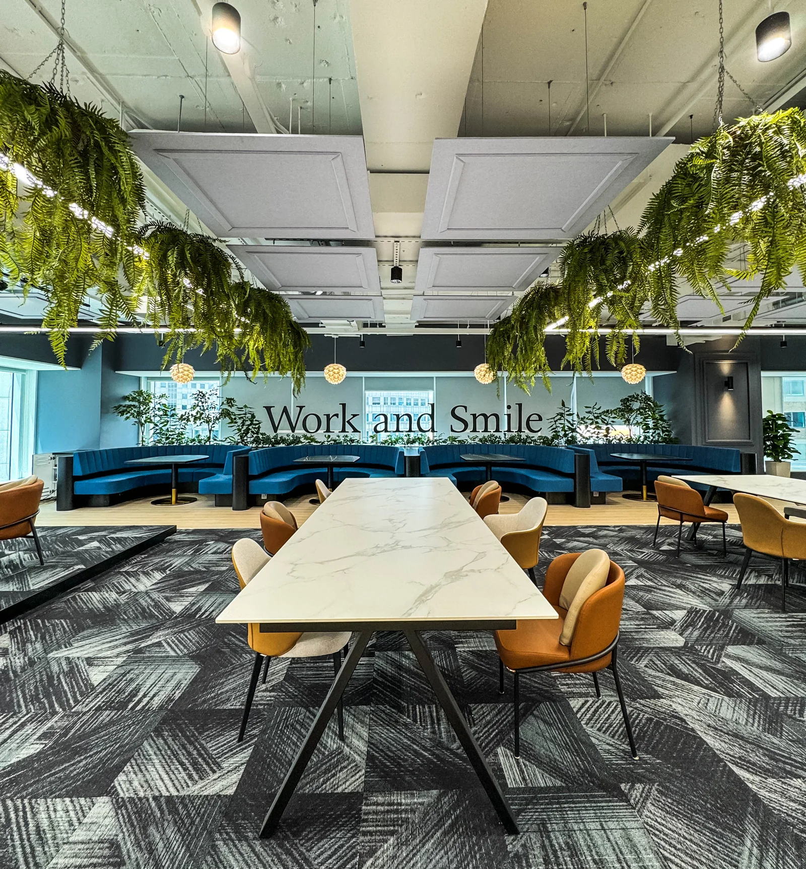 Custom suspended acoustic panels with artificial greenery and integrated lighting in a workplace