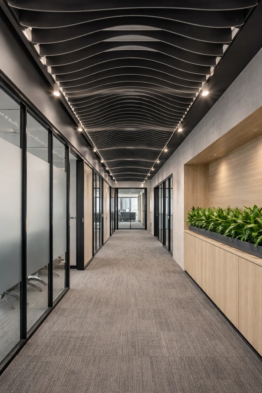 Black wave acoustic baffles ceiling system in an office corridor